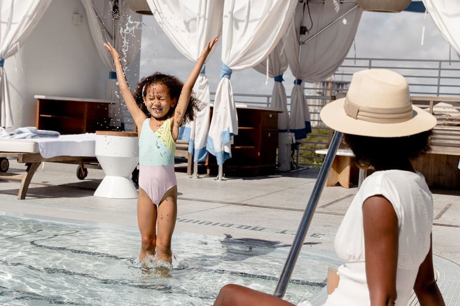 young child splashing in a pool