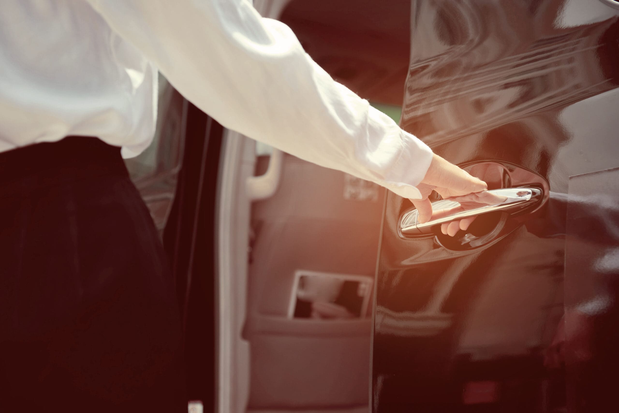 external shot of arm opening car door via handle